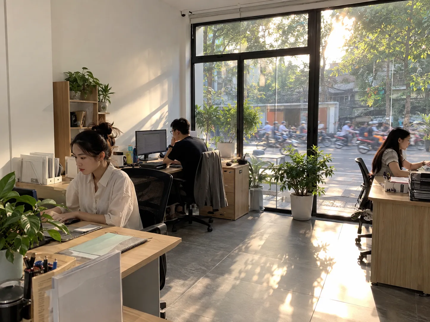 Nhân viên làm việc tại văn phòng thoáng sáng bên cửa kính lớn